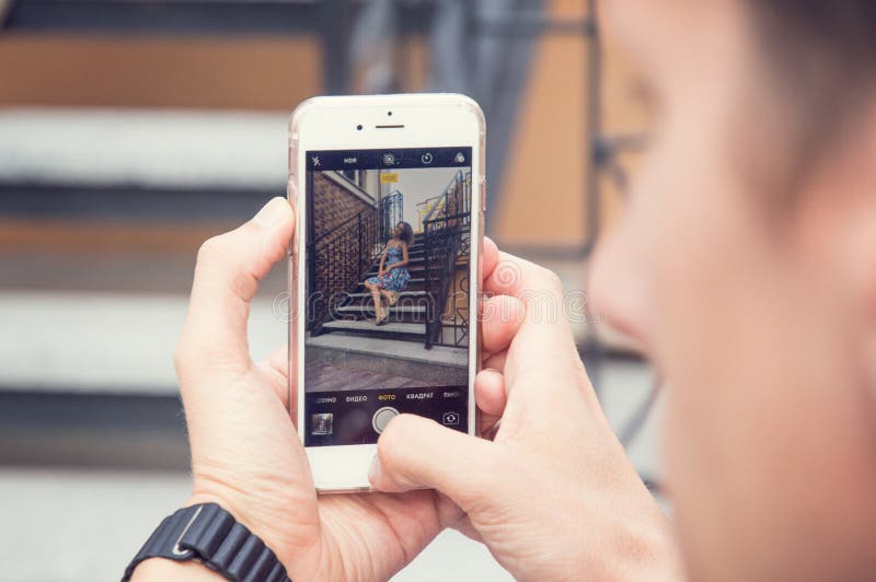 Mężczyzny fotografie na telefonie jego ukochany Zamazany schody w tle obraz royalty free Mężczyzny fotografie na telefonie jego ukochany Zamazany schody w tle obraz royalty free