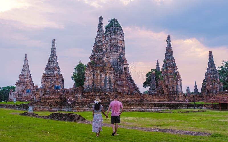 Mężczyźni i kobiety z tą wizytą turystyczną w tajlandii ayutthaya na wat chaiwatthanaram podczas zachodu słońca zdjęcia stock