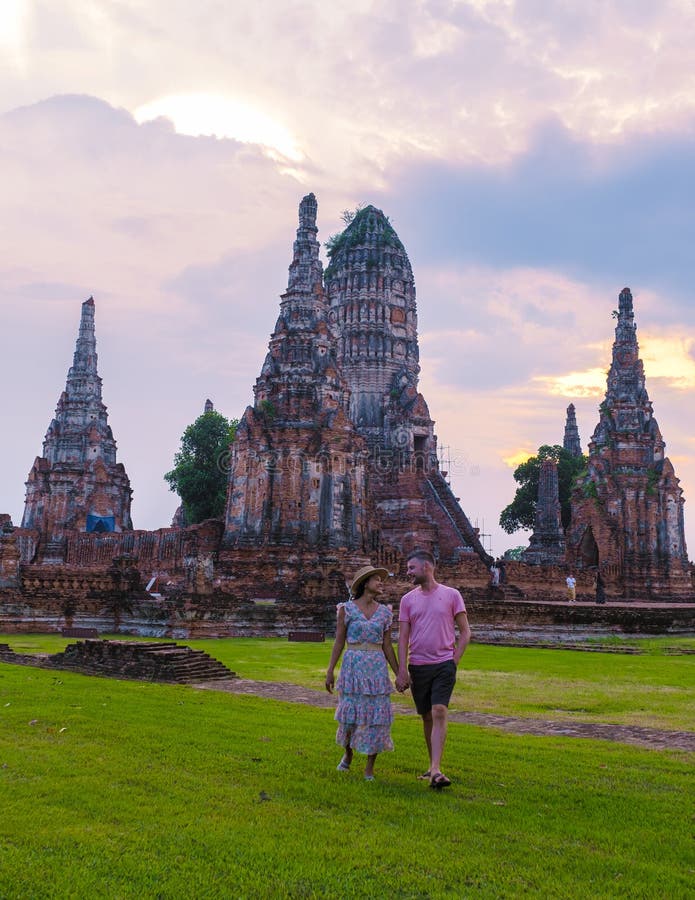 Mężczyźni i kobiety z tą wizytą turystyczną w tajlandii ayutthaya na wat chaiwatthanaram podczas zachodu słońca obraz stock
