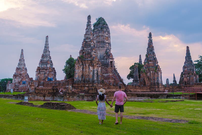 Mężczyźni i kobiety z tą wizytą turystyczną w tajlandii ayutthaya na wat chaiwatthanaram podczas zachodu słońca zdjęcia royalty free