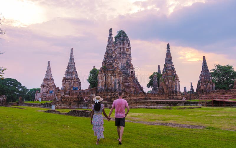 Mężczyźni i kobiety z tą wizytą turystyczną w tajlandii ayutthaya na wat chaiwatthanaram podczas zachodu słońca obraz royalty free