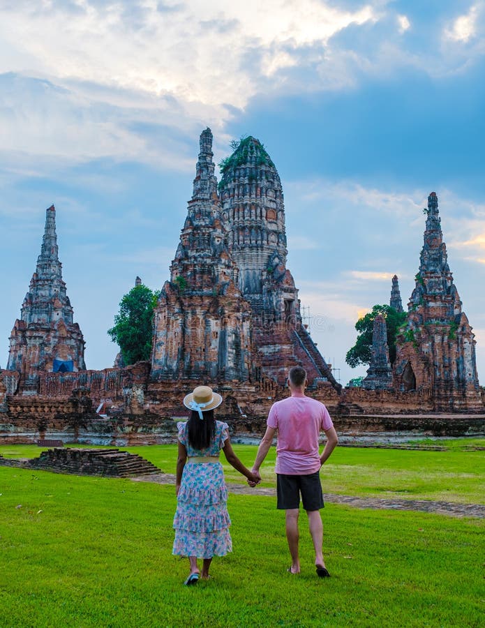 Mężczyźni i kobiety z tą wizytą turystyczną w tajlandii ayutthaya na wat chaiwatthanaram podczas zachodu słońca zdjęcia royalty free
