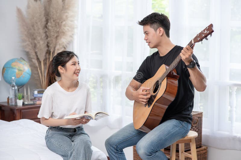 Mężczyźni siedzący na gitarze i kobiety trzymający książki i śpiewający obrazy stock