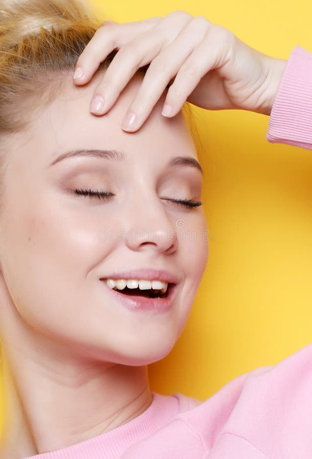 Młoda blond kobieta z zamkniętymi oczami nad żółtym tłem, zdjęcia stock Młoda blond kobieta z zamkniętymi oczami nad żółtym tłem, zdjęcia stock