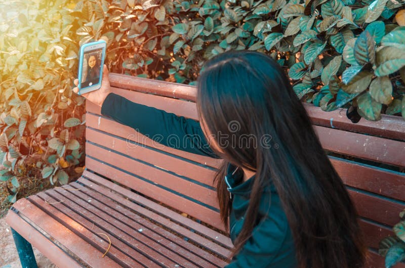 Młoda dama bierze selfie na ławce zdjęcie royalty free Młoda dama bierze selfie na ławce zdjęcie royalty free