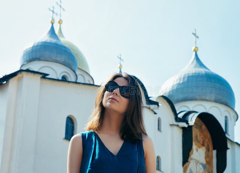 Młoda dziewczyna jest ubranym okulary przeciwsłoneczni katedrę St Sophia w Kremlin Veliky Novgorod Rosja zdjęcia stock Młoda dziewczyna jest ubranym okulary przeciwsłoneczni katedrę St Sophia w Kremlin Veliky Novgorod Rosja zdjęcia stock
