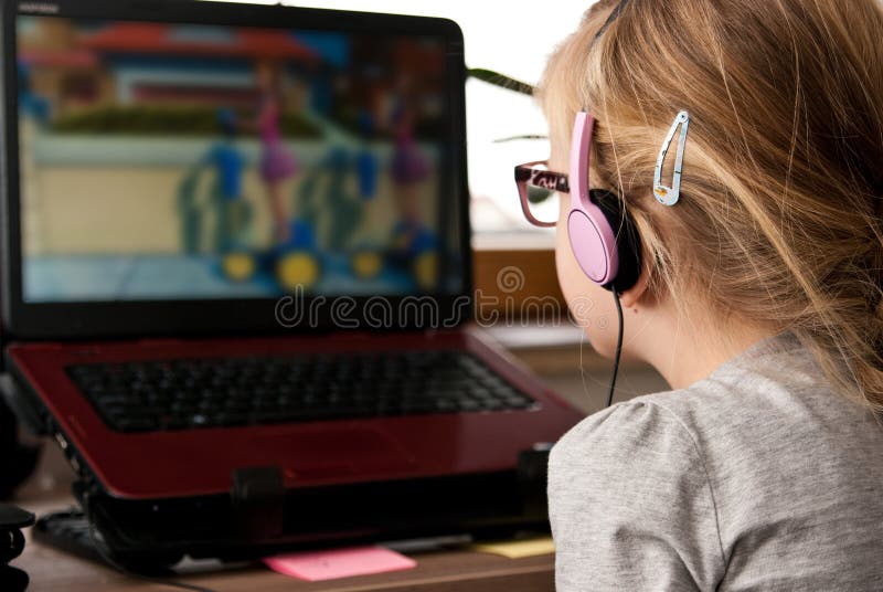 Back view of a young cute girl wearing eyeglasses, looking attentively at laptop computer screen. Back view of a young cute girl wearing eyeglasses, looking attentively at laptop computer screen.