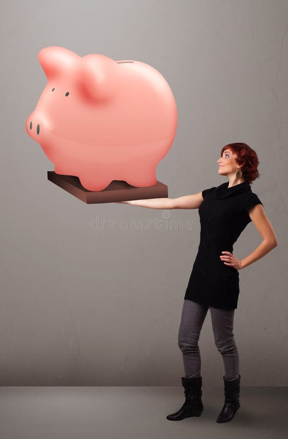 Młoda dziewczyna trzyma ogromnego savings prosiątka banka fotografia stock Młoda dziewczyna trzyma ogromnego savings prosiątka banka fotografia stock
