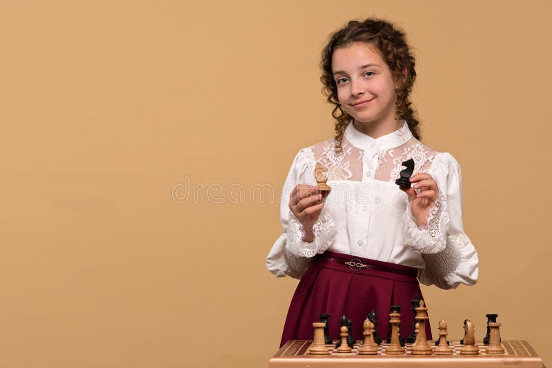 Młoda dziewczyna trzymająca czarno-białe rycerki szachowe fotografia royalty free