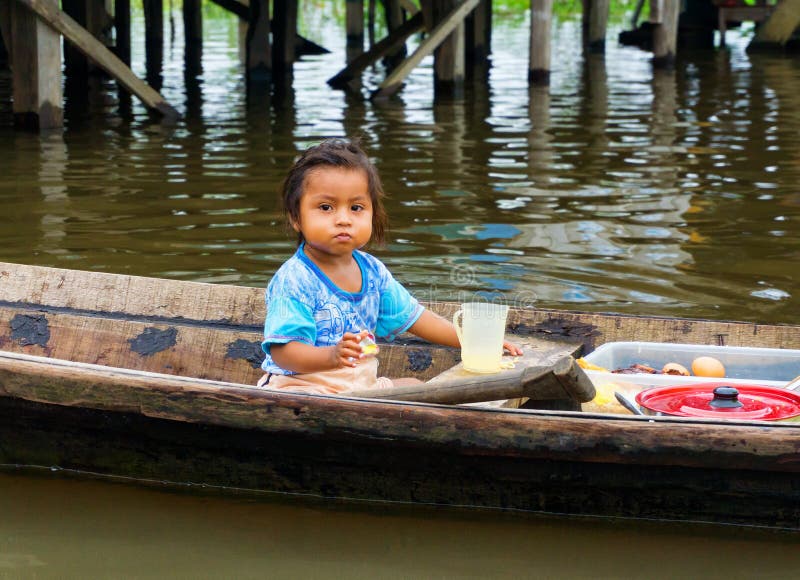 IQUITOS, PERU - MARCH 17: Young girl in a canoe in Iquitos, Peru on March 17, 2015. IQUITOS, PERU - MARCH 17: Young girl in a canoe in Iquitos, Peru on March 17, 2015