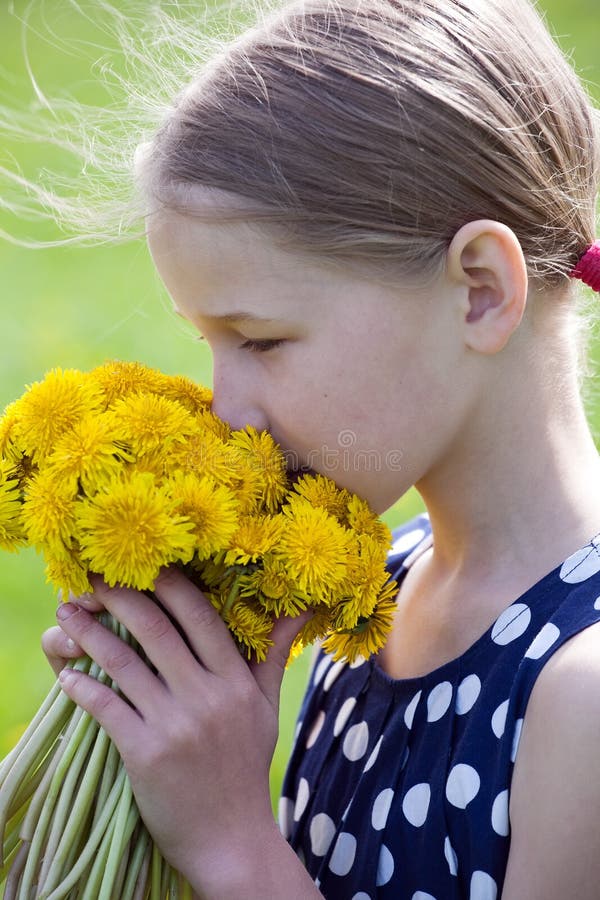Młoda dziewczyna wącha wiązkę dandelions obrazy royalty free Młoda dziewczyna wącha wiązkę dandelions obrazy royalty free
