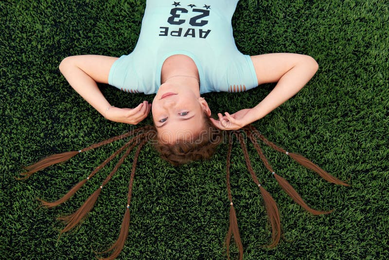Młoda jaskrawa dziewczyna kocha sporty nastoletniej dziewczyny lying on the beach na trawa odgórnym widoku obrazy stock Młoda jaskrawa dziewczyna kocha sporty nastoletniej dziewczyny lying on the beach na trawa odgórnym widoku obrazy stock