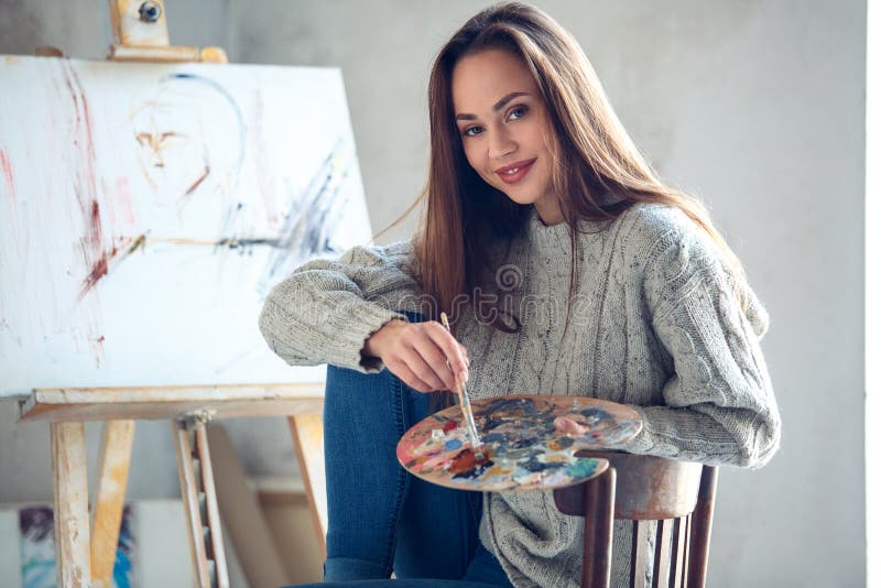 Młoda kobieta artysta maluje w domu kreatywnie mienie paletę zdjęcia stock Młoda kobieta artysta maluje w domu kreatywnie mienie paletę zdjęcia stock