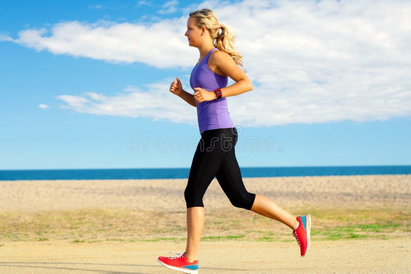 Młoda kobieta jogging wzdłuż plaży obrazy royalty free Młoda kobieta jogging wzdłuż plaży obrazy royalty free