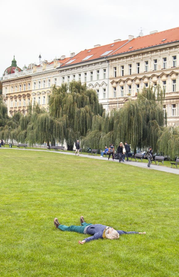 Młoda kobieta odpoczywa kłaść na trawie w miasto parku zdjęcie stock Młoda kobieta odpoczywa kłaść na trawie w miasto parku zdjęcie stock