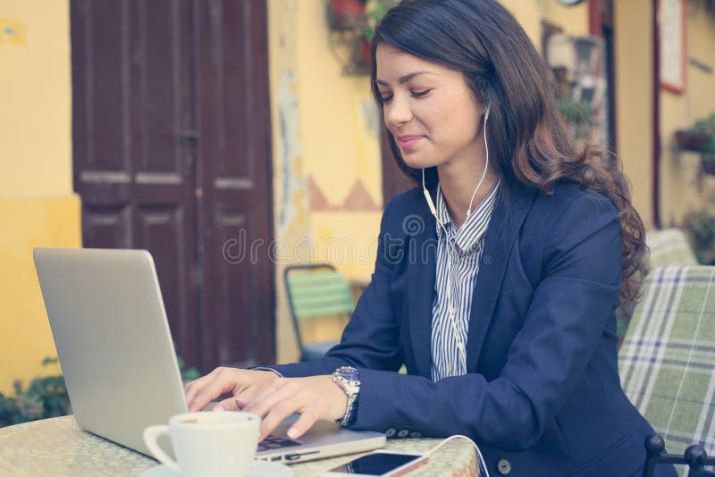 Młoda kobieta pracuje na laptopie, słuchająca muzyka obrazy royalty free Młoda kobieta pracuje na laptopie, słuchająca muzyka obrazy royalty free