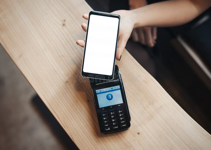 Młoda kobieta płaci przez płatniczego terminal i telefonu komórkowego w kawiarni zdjęcia royalty free Młoda kobieta płaci przez płatniczego terminal i telefonu komórkowego w kawiarni zdjęcia royalty free