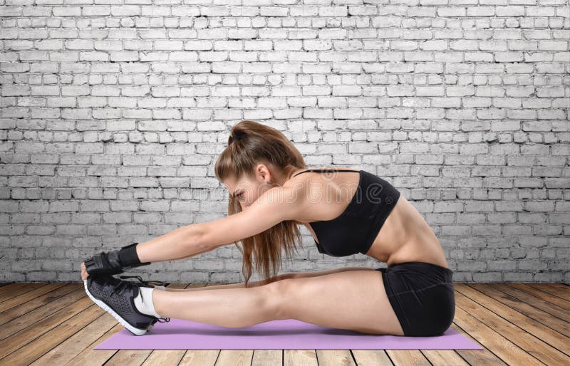 Młoda kobieta z sportowym ciałem robi rozciąganie treningowi w szkolenie sukni, ostrość na rękach obrazy stock Młoda kobieta z sportowym ciałem robi rozciąganie treningowi w szkolenie sukni, ostrość na rękach obrazy stock