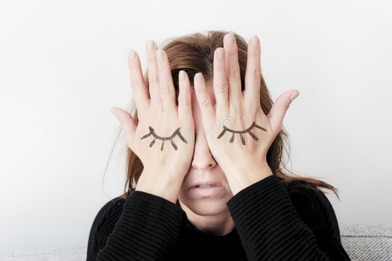 Młoda kobieta zakrywa ona oczy z jej palmami Oczy malujący na jej ręce
