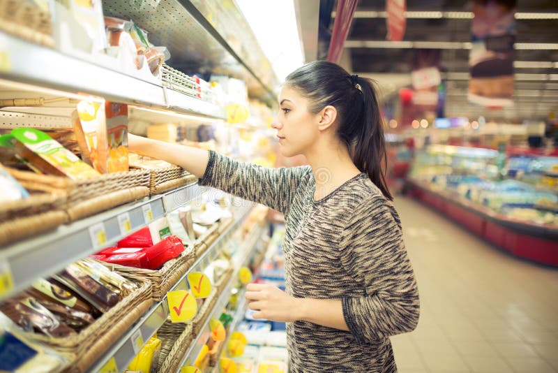 Młoda kobieta zakupy dla przepisów składników w wielkim supermarkecie Robiący zakupy dla sklepów spożywczych, gospodarstwa domowe