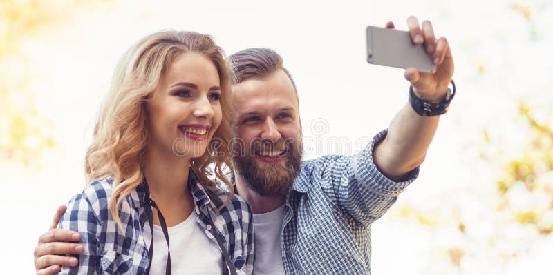 Młoda kochająca para robi selfie fotografii w jesień parku obraz stock Młoda kochająca para robi selfie fotografii w jesień parku obraz stock