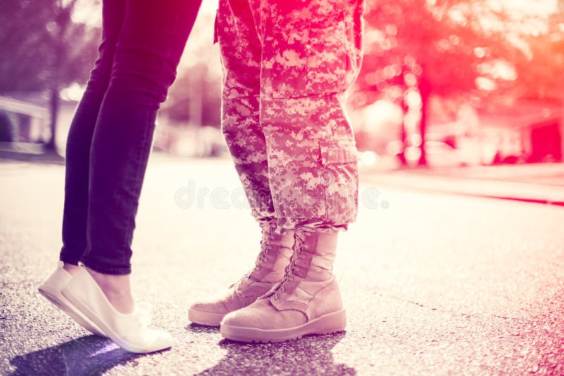Młoda militarna para całuje each inny, powrót do domu pojęcie