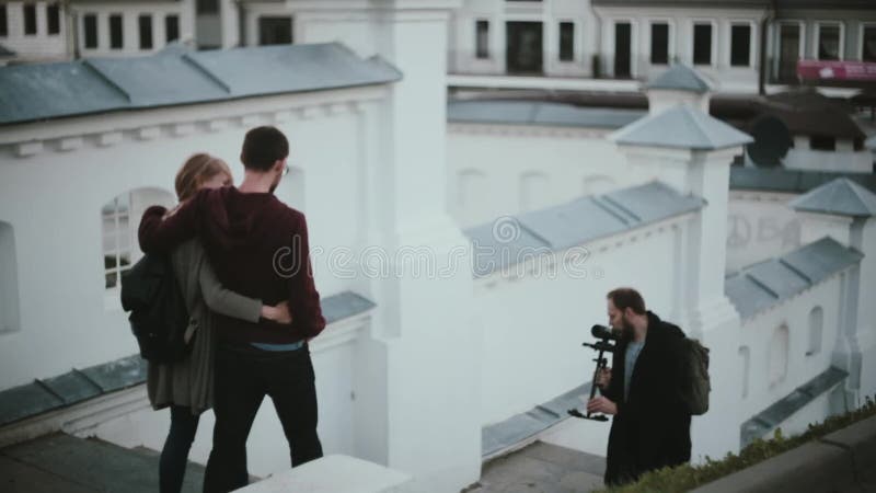 Młoda piękna para iść w dół na schodkach Męski fotograf bierze fotografie elegancki mężczyzna i kobieta
