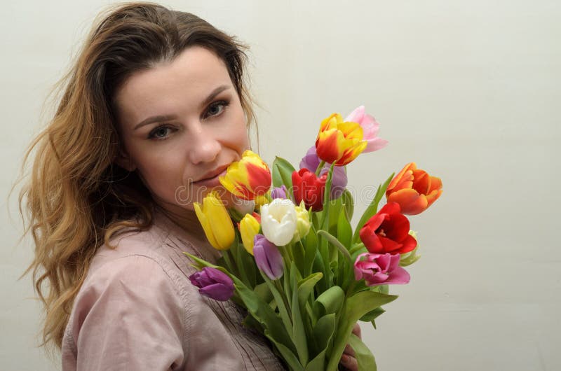 Młoda powabna dziewczyna z bukietem kwiaty - barwiący tulipany fotografia stock Młoda powabna dziewczyna z bukietem kwiaty - barwiący tulipany fotografia stock