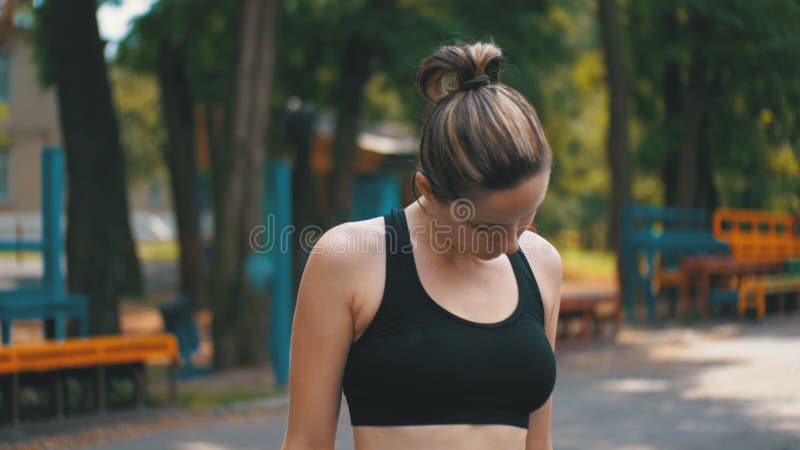 Młoda Sportowa kobieta w sporta stroju Robi szyi na sporta polu w parku zbiory Młoda Sportowa kobieta w sporta stroju Robi szyi na sporta polu w parku zbiory