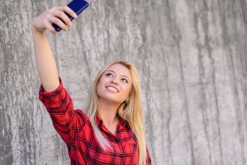 Młoda uśmiechnięta dziewczyna z piękną twarzą bierze autoportret na jej smartphone Blondynka włosy, promieniejący uśmiech Jest ub zdjęcia royalty free Młoda uśmiechnięta dziewczyna z piękną twarzą bierze autoportret na jej smartphone Blondynka włosy, promieniejący uśmiech Jest ub zdjęcia royalty free