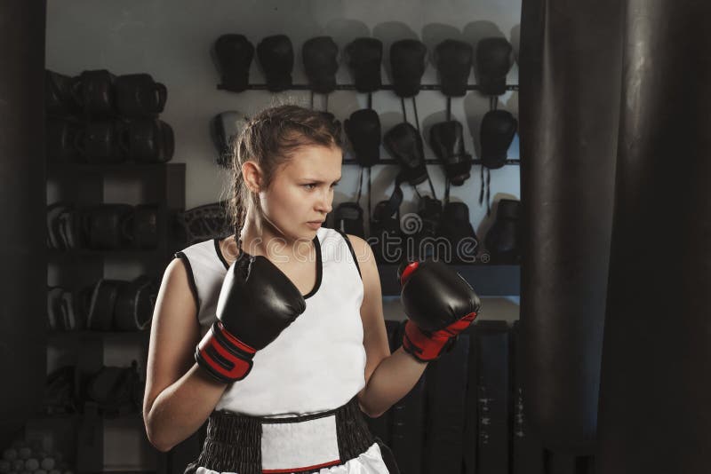 Młoda zdecydowana atleta trzyma bokserskiego szkolenie w gym zdjęcie royalty free Młoda zdecydowana atleta trzyma bokserskiego szkolenie w gym zdjęcie royalty free