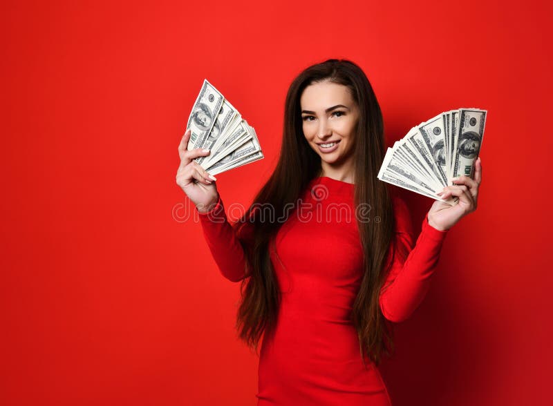 Młoda ładna kobieta w czerwieni smokingowy chować za wiązką pieniędzy banknoty obrazy royalty free Młoda ładna kobieta w czerwieni smokingowy chować za wiązką pieniędzy banknoty obrazy royalty free