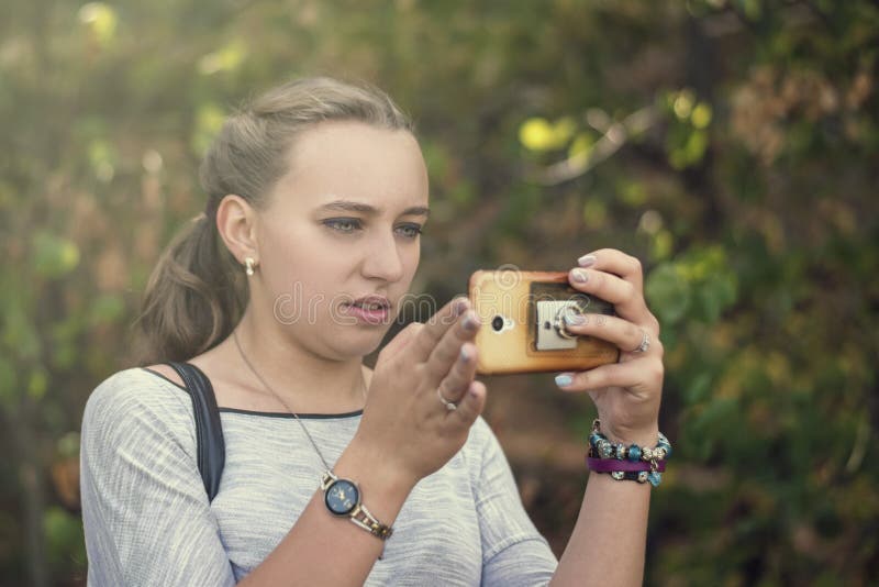 Młoda śliczna dziewczyna koncentruje na telefonie komórkowym podczas gdy na na obraz stock Młoda śliczna dziewczyna koncentruje na telefonie komórkowym podczas gdy na na obraz stock