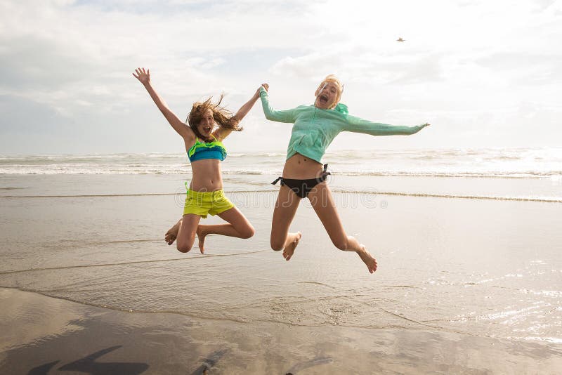 Two girls jumping at the beach. Two girls jumping at the beach