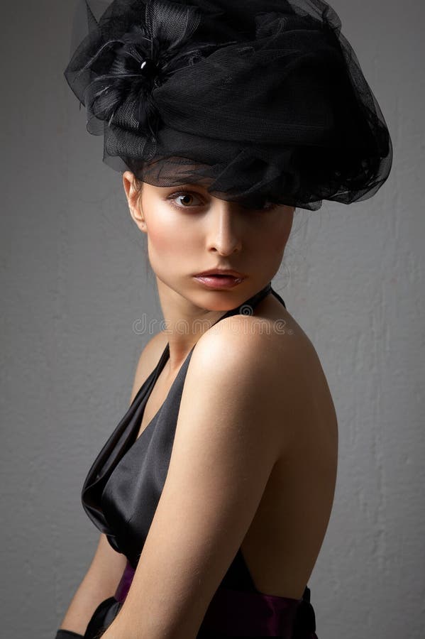 Young woman with hat on the grey background. Young woman with hat on the grey background