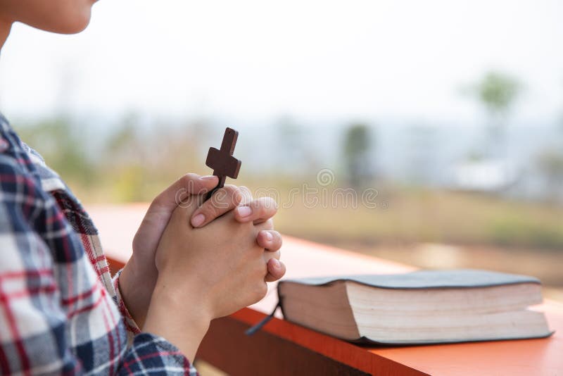 Młode modlenie kobiety ręki z drewnianym krzyżem i Świętą biblią ksi?? kowa poj? cia krzy? a religia fotografia royalty free