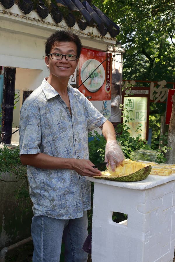 Młodego chińskiego męskiego sprzedawcy ulicznego tnący jackfruit zdjęcie stock