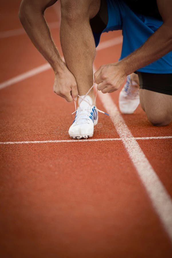 Młodego Człowieka biegacz wiąże jego buty na bieg śladzie Shoelaces, Miastowy jogger zdjęcie royalty free