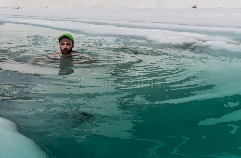 Young man bathing in the ice hole in the mountains. Young man bathing in the ice hole in the mountains