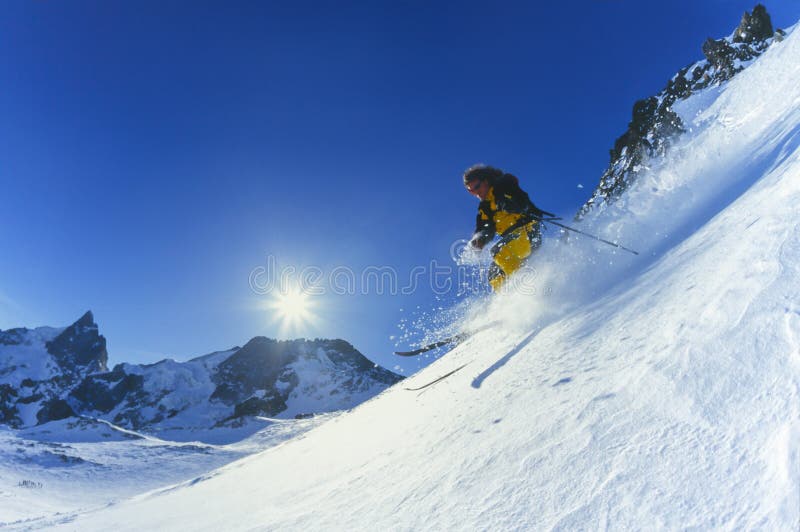 Młodego człowieka narciarstwa proszka śnieg w górach w zimie