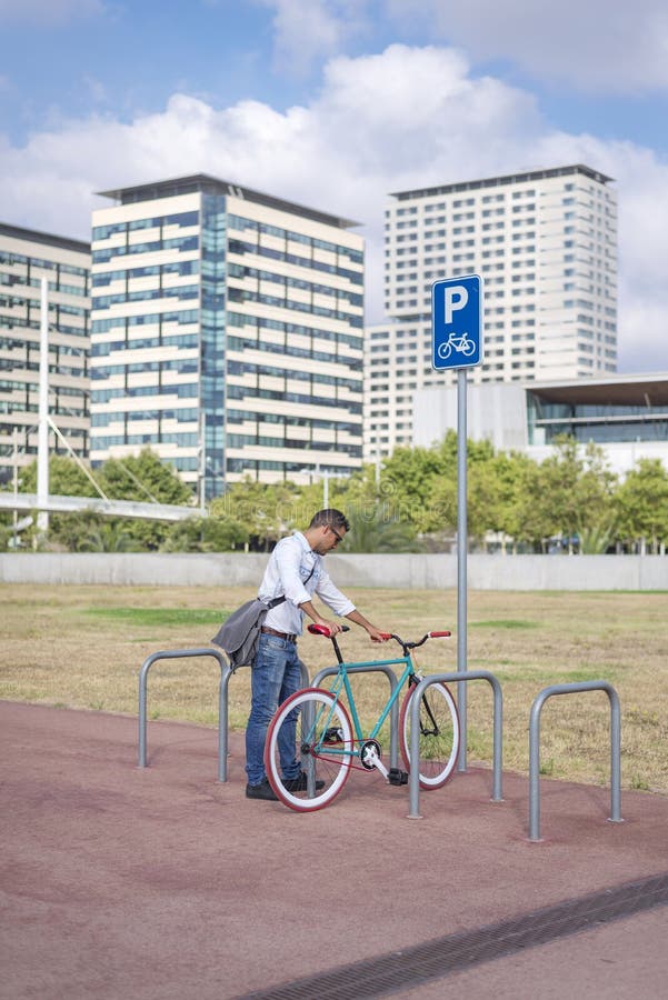 Młodego człowieka parking bicykl na miasto ulicie zdjęcia stock Młodego człowieka parking bicykl na miasto ulicie zdjęcia stock