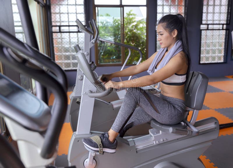 Młodej dziewczyny ćwiczenia roweru cardio trening przy sprawności fizycznej gym fotografia stock Młodej dziewczyny ćwiczenia roweru cardio trening przy sprawności fizycznej gym fotografia stock