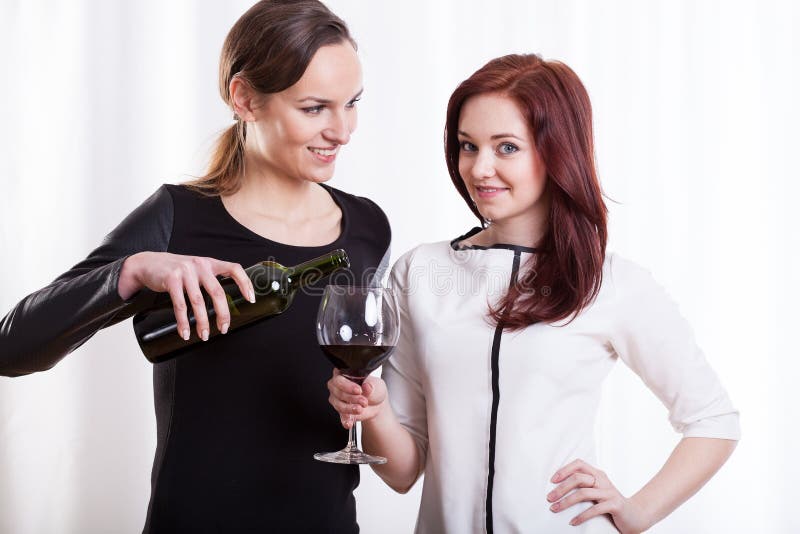 Młodej kobiety dolewania wino dla jej przyjaciela zdjęcia royalty free