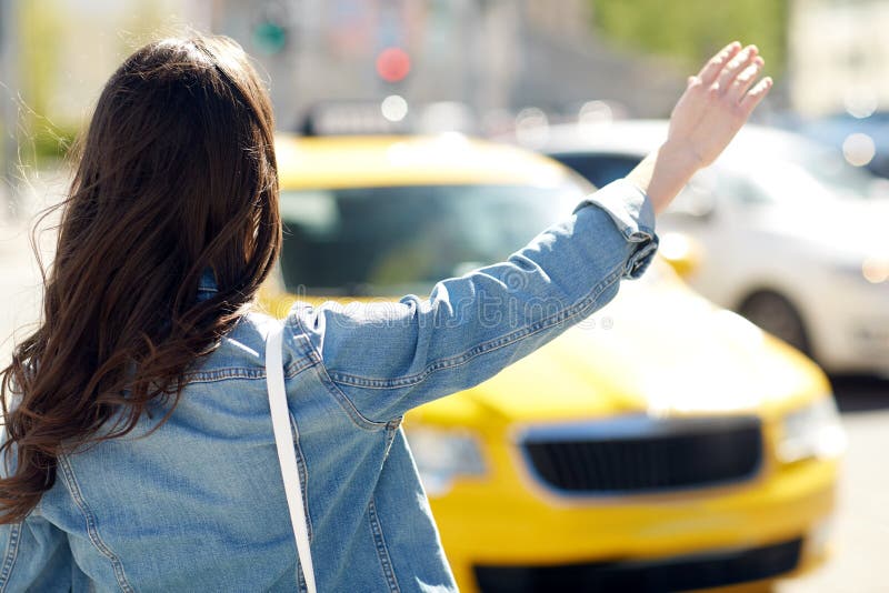 Młodej kobiety lub dziewczyny chwytający taxi na miasto ulicie obraz stock Młodej kobiety lub dziewczyny chwytający taxi na miasto ulicie obraz stock