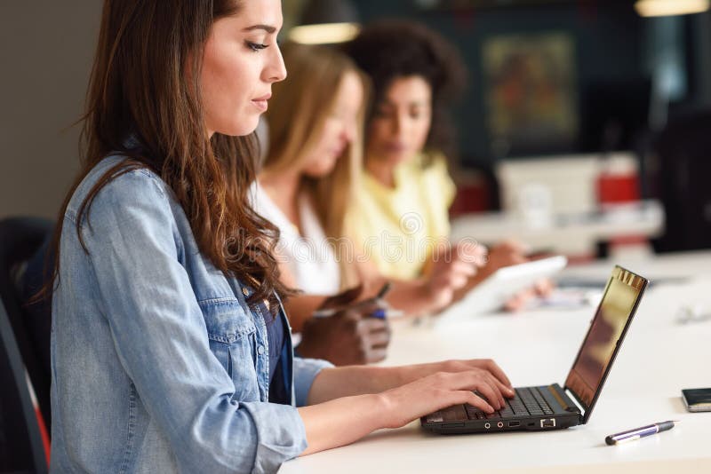 Młodej kobiety studiowanie z laptopem na białym biurku zdjęcie stock Młodej kobiety studiowanie z laptopem na białym biurku zdjęcie stock