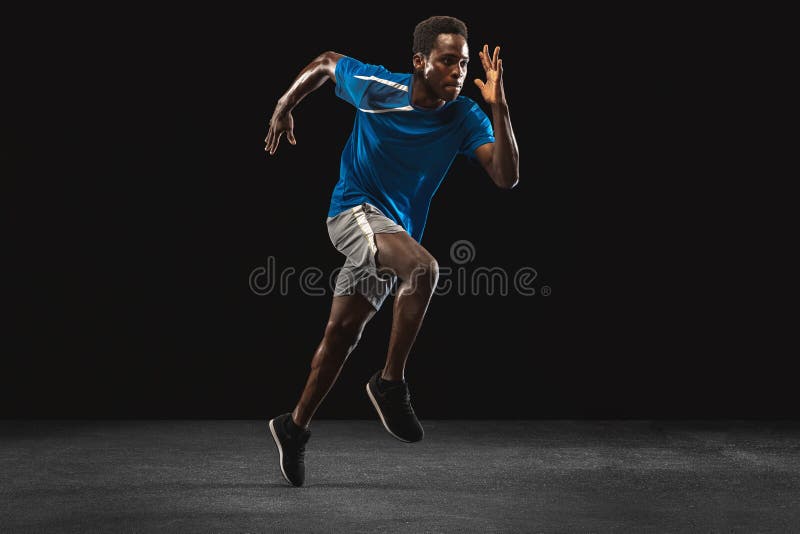 Młody africanamerican mężczyzna, sport trening samotnie na czarnym tle.