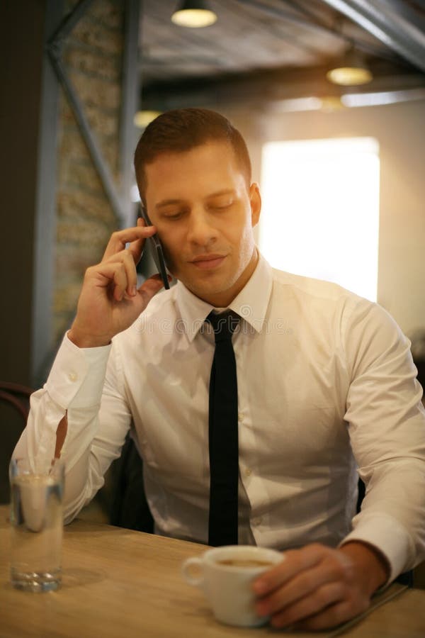 Młody biznesmen opowiada na telefonie fotografia stock Młody biznesmen opowiada na telefonie fotografia stock