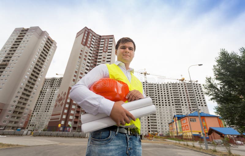 Młody budowa inżynier w zbawczym kamizelki mienia hardhat zdjęcie stock