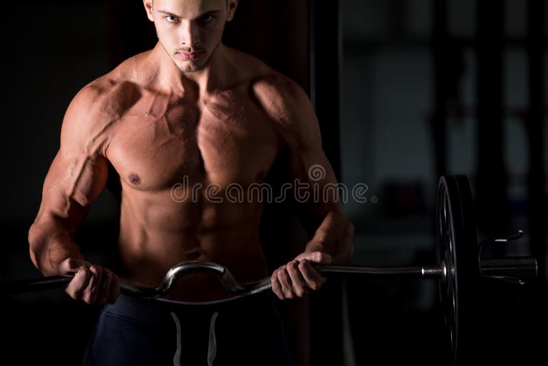 Młody człowiek podnosi barbell w sprawności fizycznej centrum zdjęcia royalty free Młody człowiek podnosi barbell w sprawności fizycznej centrum zdjęcia royalty free