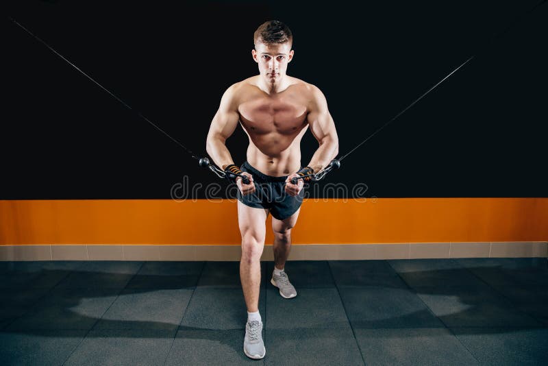 Młody człowiek robi rozcięcia na symulancie w gym Ćwiczy dla mięśni klatki piersiowej skrzyżowanie obraz royalty free Młody człowiek robi rozcięcia na symulancie w gym Ćwiczy dla mięśni klatki piersiowej skrzyżowanie obraz royalty free